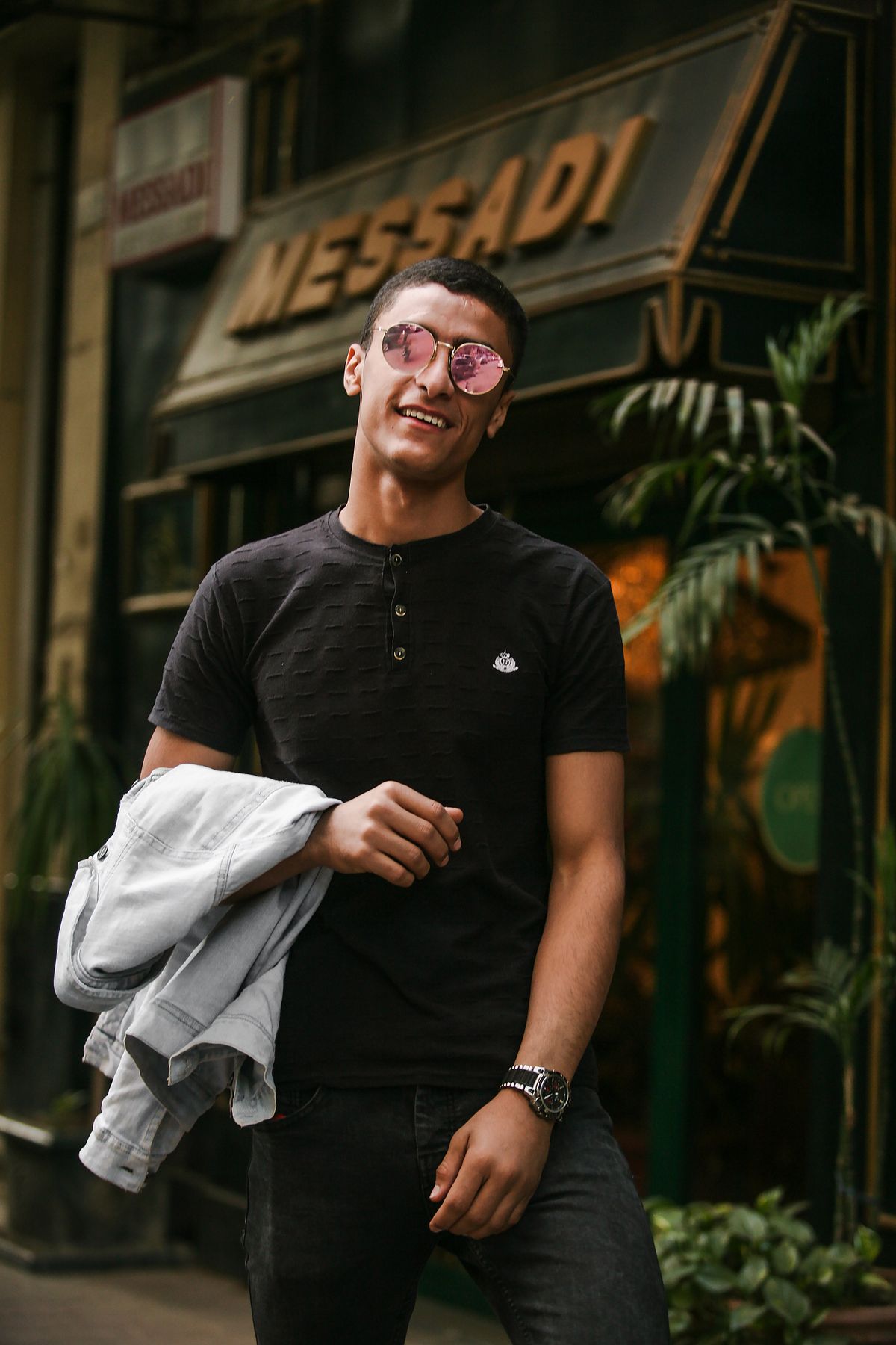 A black short-sleeve Henley with a three-button placket.