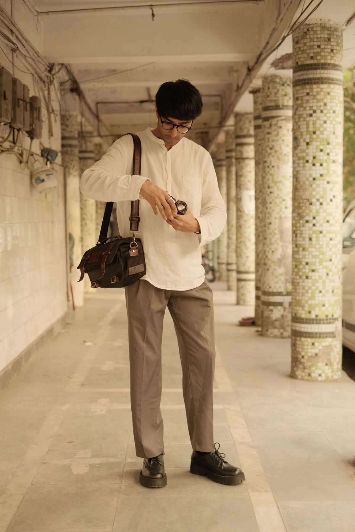 Olive-toned trousers worn with an untucked light shirt.