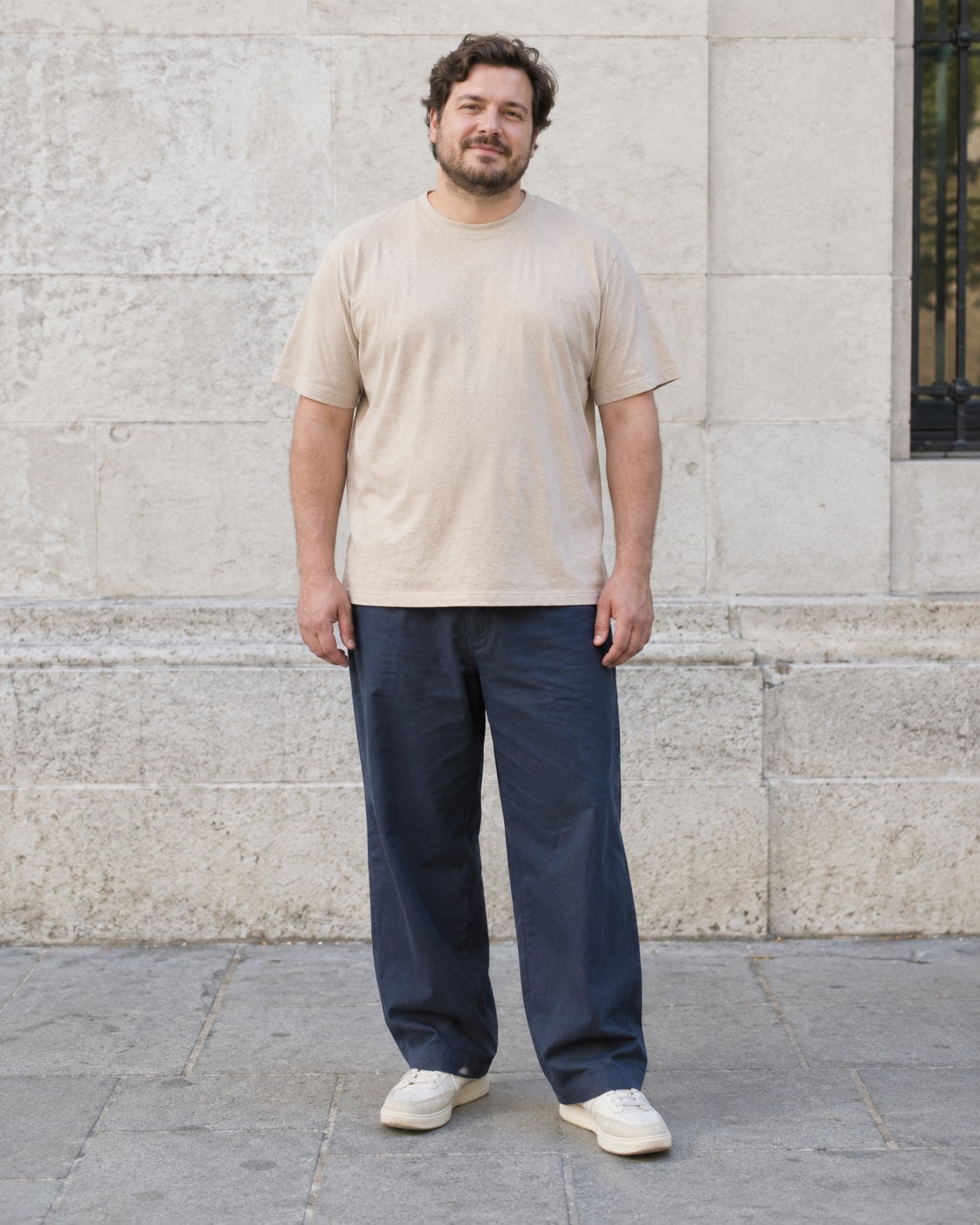 A loose beige T-shirt and roomy navy trousers worn together.