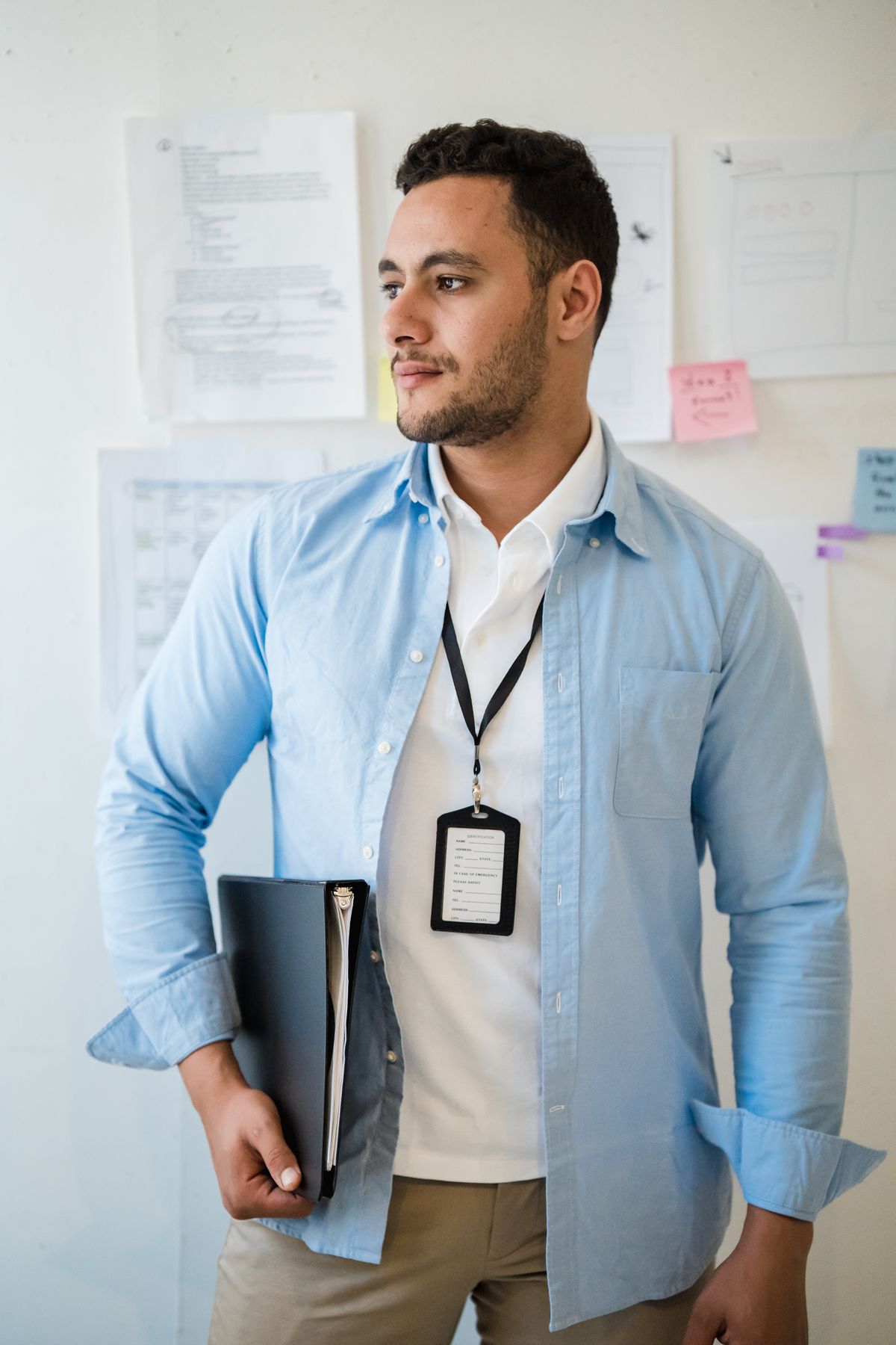 An open blue shirt over a white top with chinos in an office.