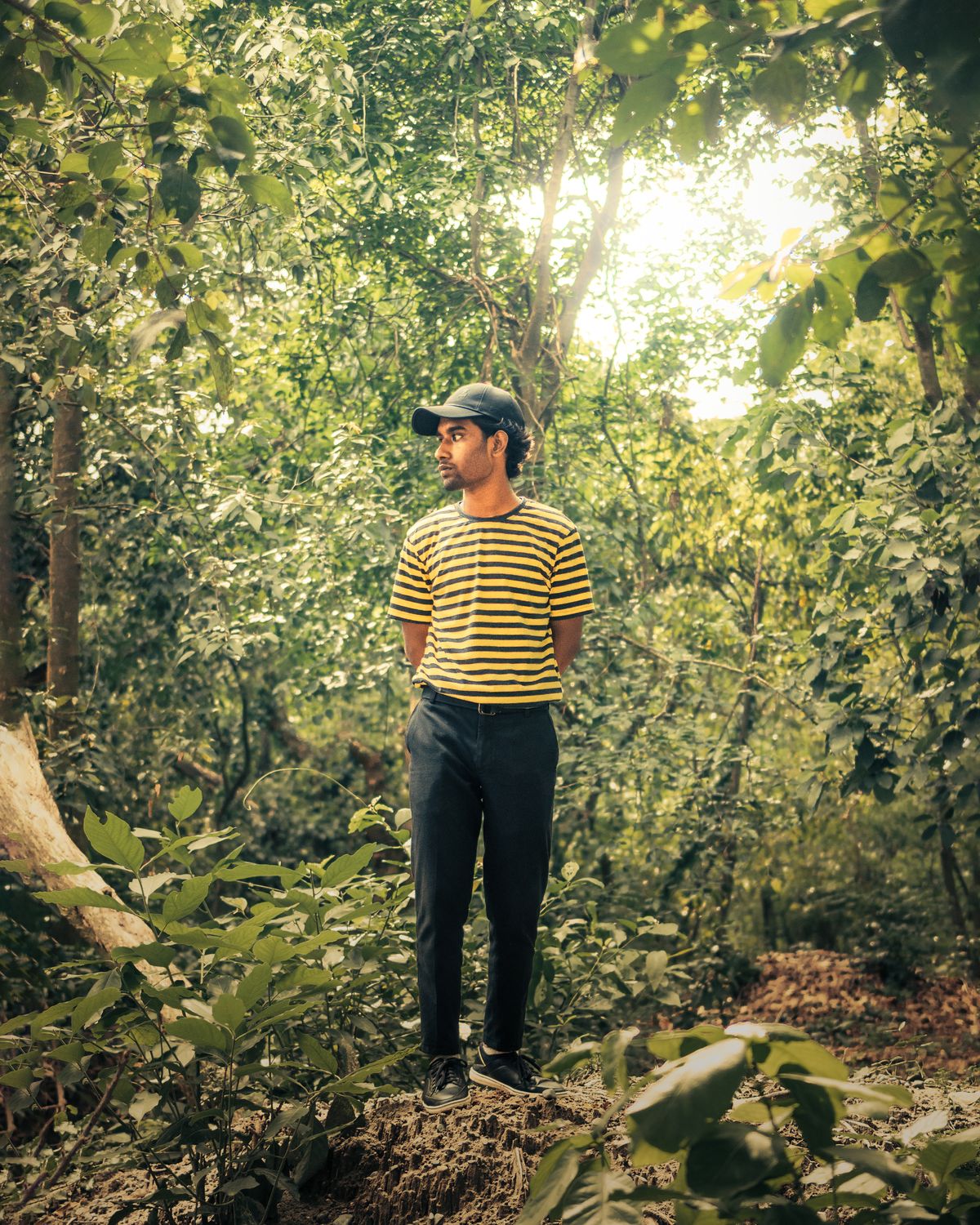 A yellow and black striped T-shirt worn with plain dark trousers.