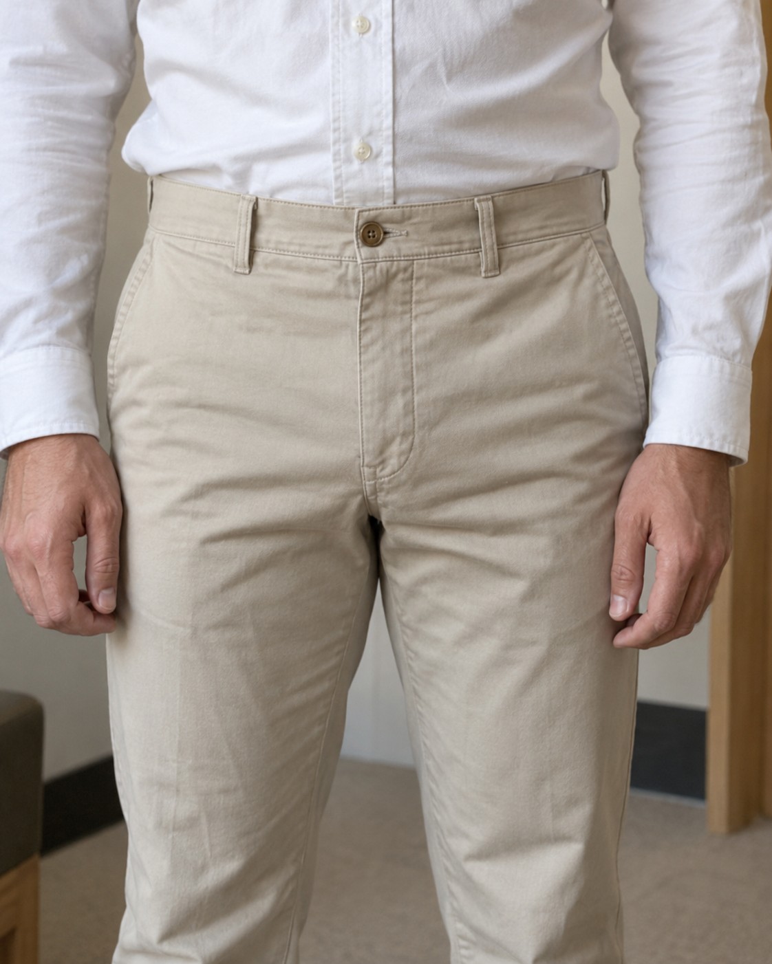 Stone trousers with a high waistband worn with a tucked white shirt.